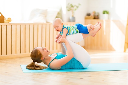 Maman qui fait du sport et du yoga avec bébé à la maison